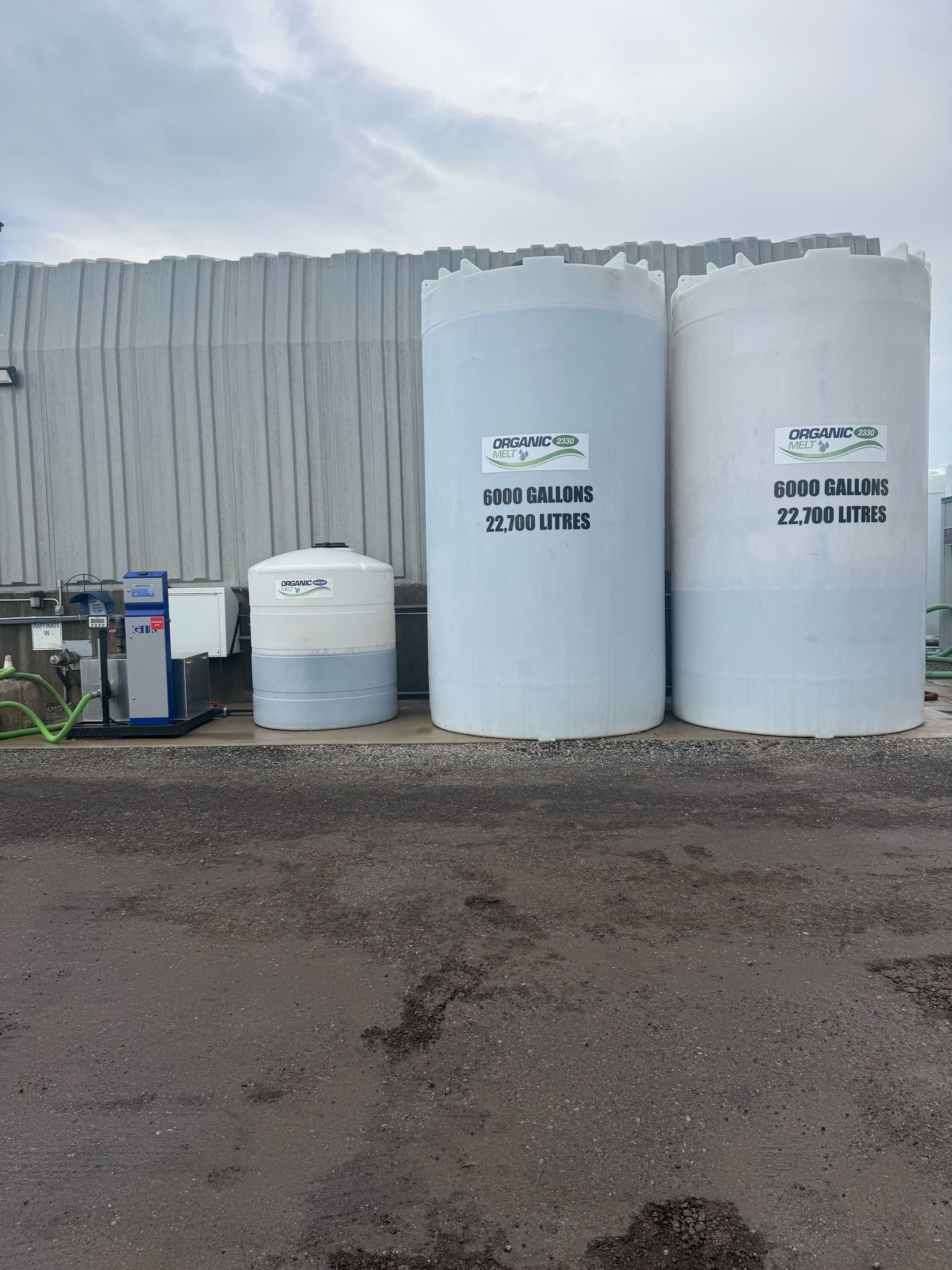 Two large white liquid storage tanks at a host site